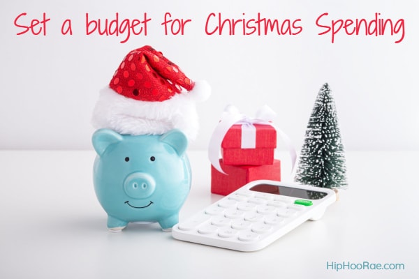 Piggy bank with Christmas Hat and  calculator next to it and some presents