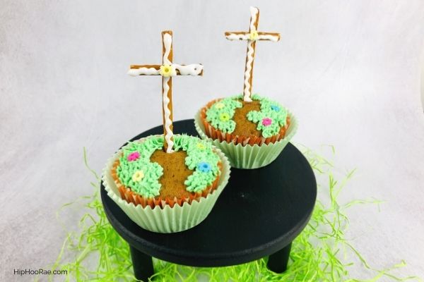 Carrot Cake Easter Cross Cupcakes on black stand with green shredded paper