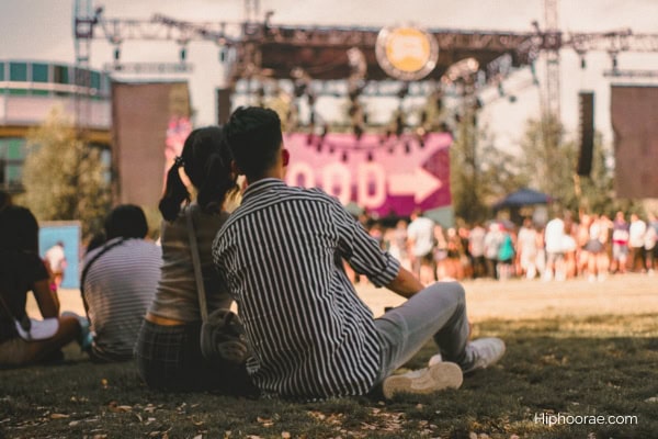 Couple sitting on grass at a live music event