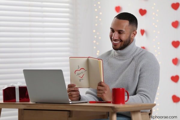 Man in front of laptop, celebrating Valentine's Day with long distance partner
