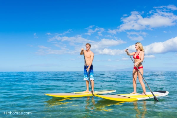 Couple paddling on their surfboards
