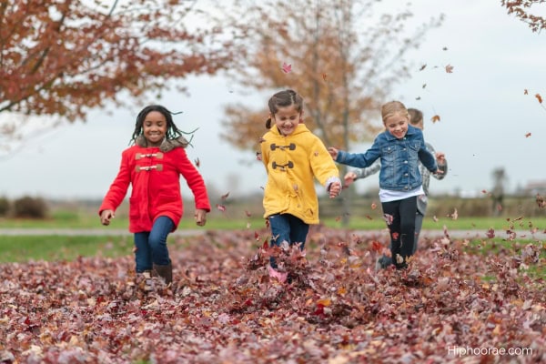 kids playing on leaf pile