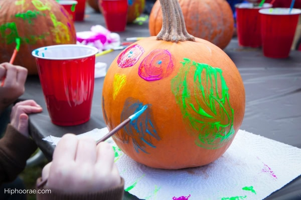 Kid painting a pumpkin