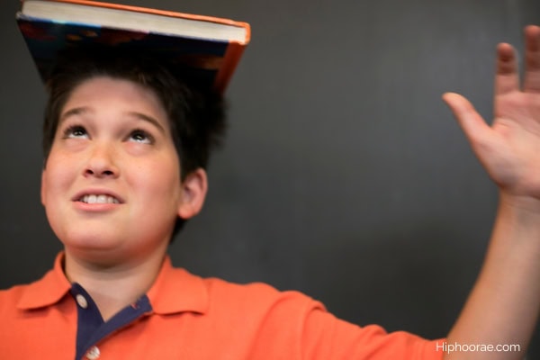 boy balancing a book on his head