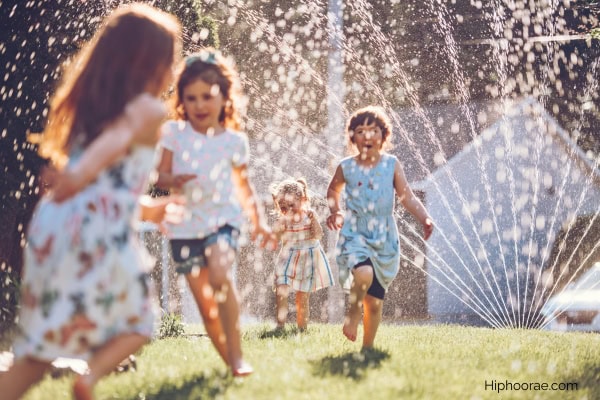 little girls running around the sprinklers