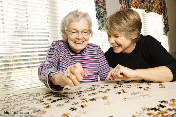 senior woman and young woman doing puzzle together