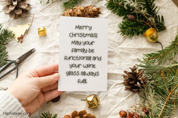 Hand holding a card with Christmas message, Christmas decor crafts in the background