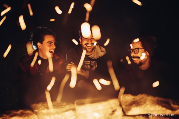 3 men friends laughing by the bonfire