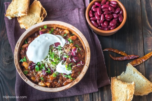 bowl of chili con carne, bowl of beans, some bread
