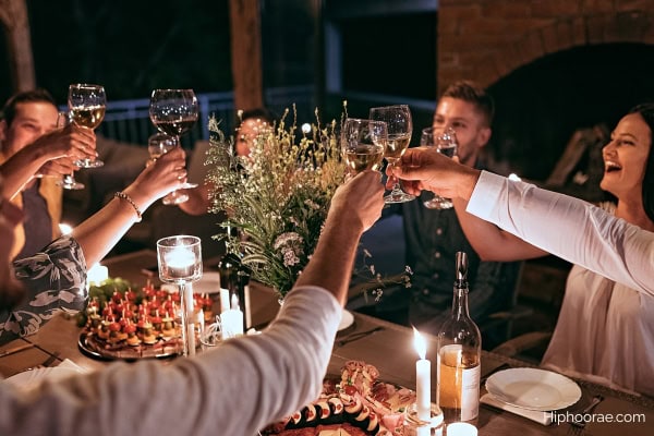 group of friends having dinner outdoors at night