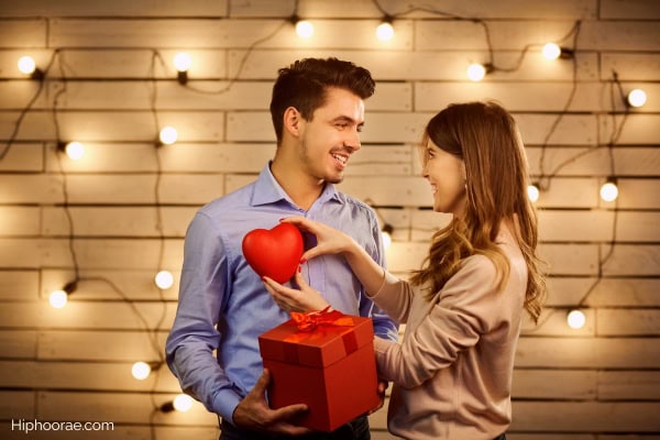 Woman holding a heart, man holding a red gift on Valentine's day