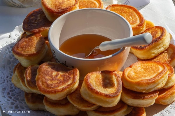 mini pancakes with a bowl of syrup at the center