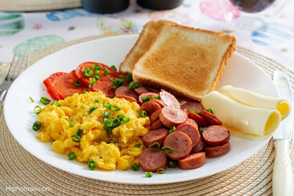 breakfast plate of eggs, sausages, toast, cheese