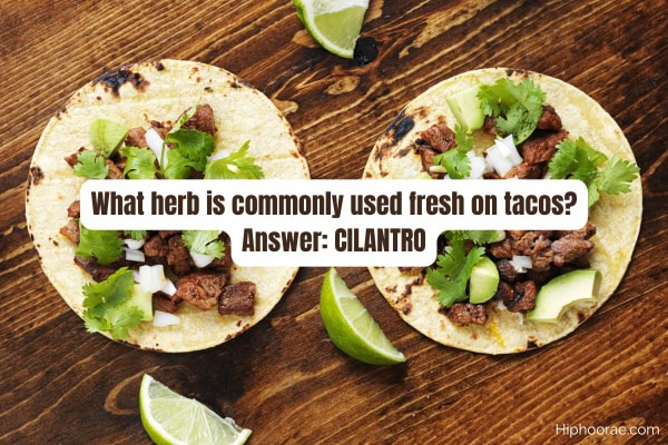 Tacos on wooden table, lime wedges, with trivia question and answer overlay