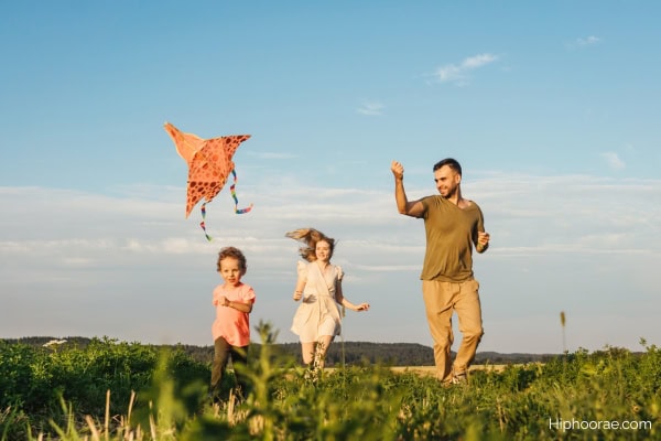 family of 3 flying a kite
