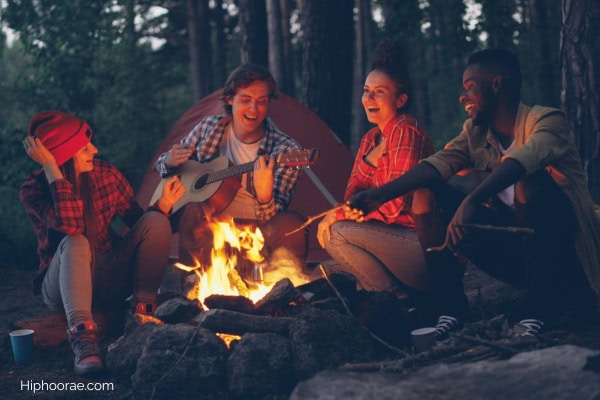group of friends in flannel around a bonfire 