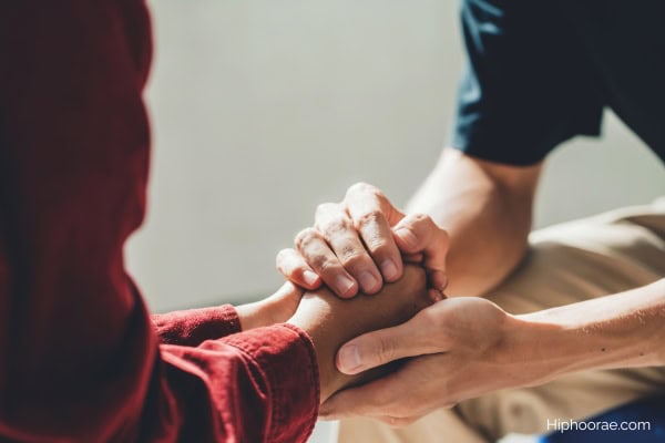 man holding woman's hands for comfort