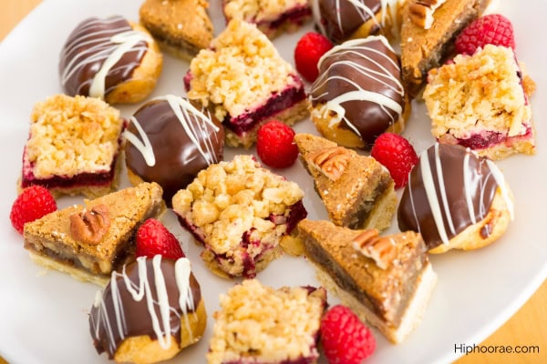 assorted desserts - cream puffs, berry crumble bars, pecan tarts, raspberries